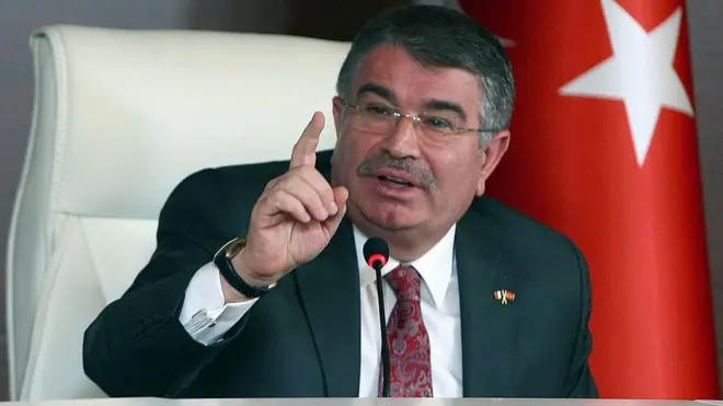 İdris Naim Şahin üzerinde bir takım elbiseyle konuşurken