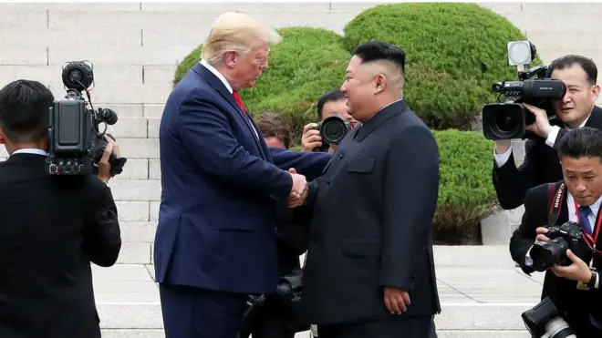 كيم جونغ اون ودونالد ترامب يتصافحان