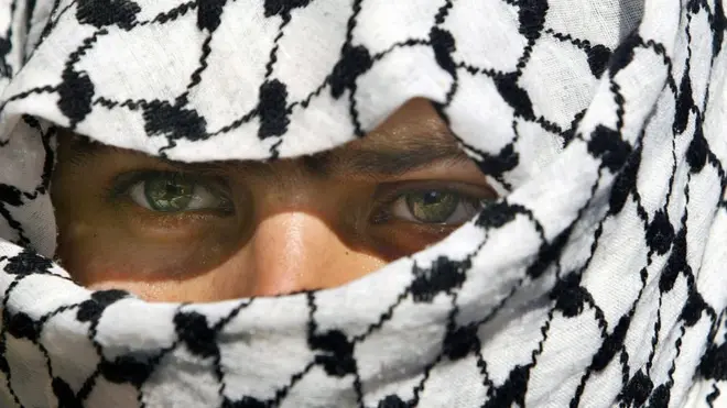 কেফায়া পরা আল-আকসা মার্টার্স ব্রিগেডের সদস্য এক ফিলিস্তিনি তরুণ। দ্বিতীয় ইন্তিফাদা অব্যাহত ছিল কয়েক বছর ধরে।