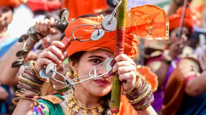 लेझीम खेळणारी तरुणी