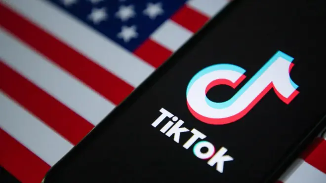 Um celular com logo do aplicativo do TikTok abertosportingbet boletocimasportingbet boletouma bandeira dos EUA