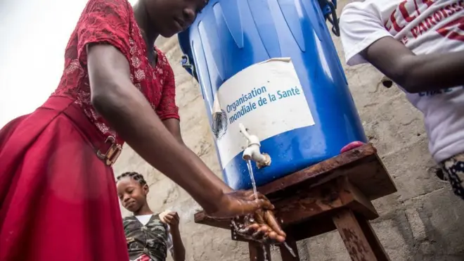 Pour prévenir la fièvre Ebola, une femme se lave les mains à l'aide d'un réservoir d'eau, après la messe de Pentecôte à l'église du Christ, à Mbandaka, dans le nord-ouest de la RDC.