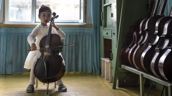 A girl plays a cello at Chongnam Kindergarten, Chongjin, North Hamgyong Province