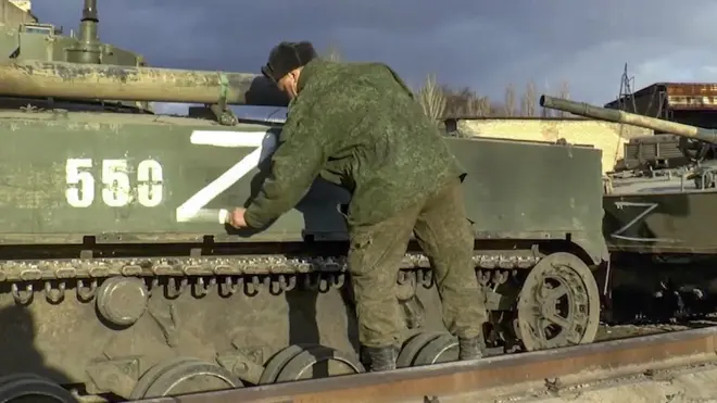 Une photo tirée d'une vidéo publiée par le service de presse du ministère russe de la Défense montre un soldat russe marquant un véhicule blindé de transport de troupes abandonné par l'armée ukrainienne lors de sa retraite dans la région de Donetsk.