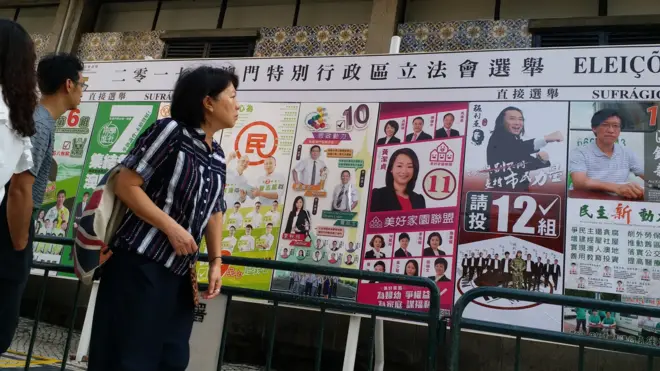 澳门葡文学校外一名路人察看选举海报(BBC中文网图片17/9/2017)