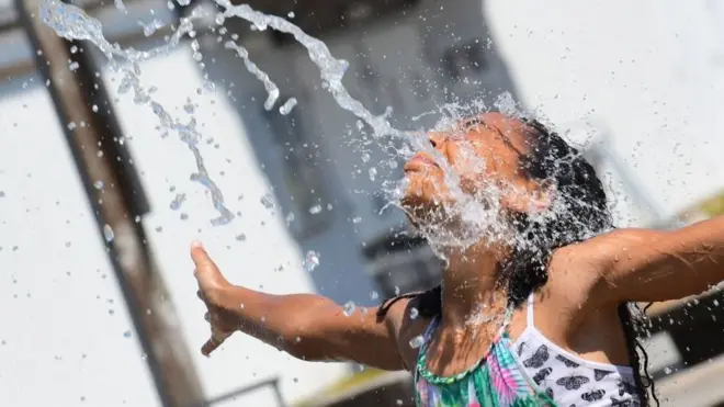 Seorang anak perempuan membasahkan diri di tengah cuaca yang sangat panas di Richmond, British Columbia, Kanada 29 Juni 2021