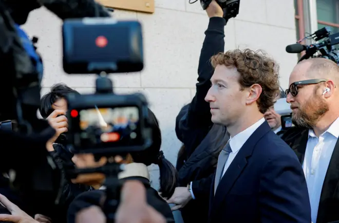 Mark Zuckerberg, vestindo um terno azul-marinho e gravata cinza, ao sair do tribunal em Los Angeles em 18 de fevereiro, cercado por fotógrafos