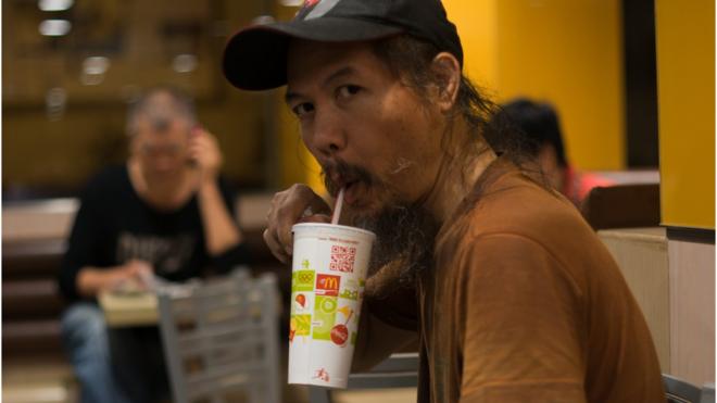 A homeless man drinks in McDonald's
