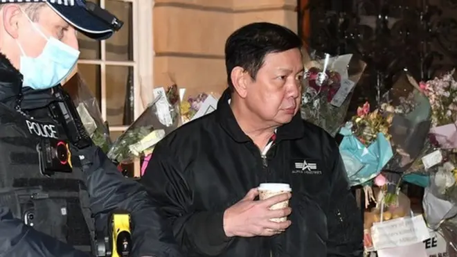 Myanmar's ambassador to the UK Kyaw Zwar Minn (R) speaks to a police officer outside the embassy in Mayfair, London