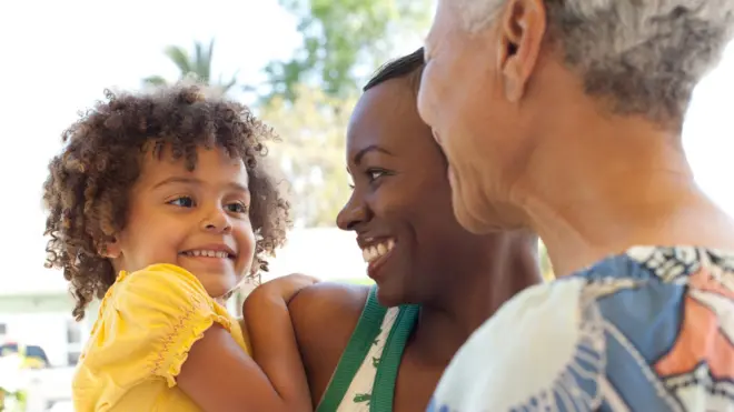 سيدتان وطفلة يضحكن