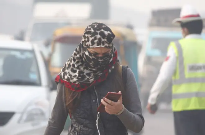 یوه مېرمنه مبایل ته ګوري