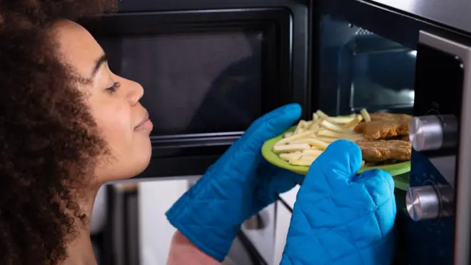Woman reheating food.