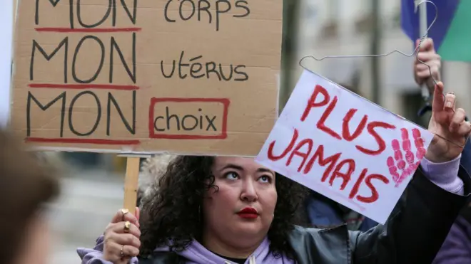 Manifestante segura cartazes que dizem “Meu corpo, meu útero, minha escolha” e “Nunca mais” durante protesto silenciosoaposta mundial de clubesapoio à revisão constitucional