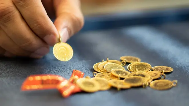 cumhuriyet altınları ve bir altın tutan el