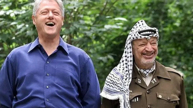 فلسطینی رہنما یاسر عرفات، امریکی صدر بل کلنٹن اور اسرائیلی وزیرِ اعظم ایہود بارک 11 جولائی 2000 کو کیمپ ڈیوڈ میں خوشگوار موڈ میں