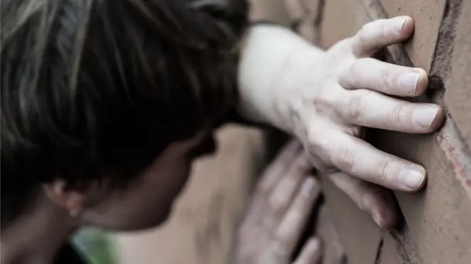 Жінка біля стіни