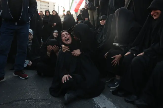 Dve žene, obučene u crno, koje plaču