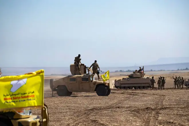 قطع حربية تحمل راية قوات سوريا الديمقراطية وعلى متنها جنود بقلب الصحراء