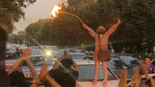 ذه إحدى الصور التي أعيد نشرها آلاف المرات على شبكات التواصل الاجتماعي لإمرأة أشعلت النار في حجابها وهي تقف سيارة.