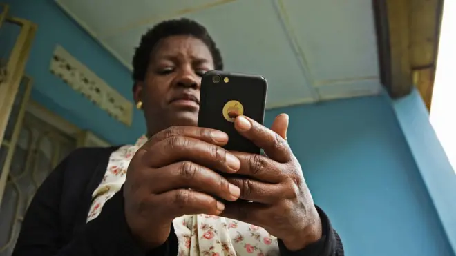 Une femme avec son smartphone Apple.