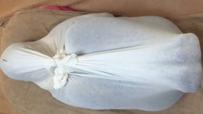 ผู้เข้ารับการบำบัดจะถูกห่อมัดทั้งตัวด้วยผ้าขาวบาง ดูคล้ายกับการมัดตราสัง