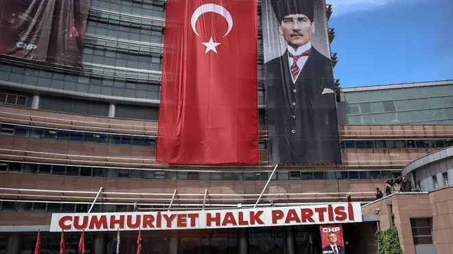 CHP yazan binada Türk bayrağı, Atatürk'ün resmi ve Özgür Özel posteri
