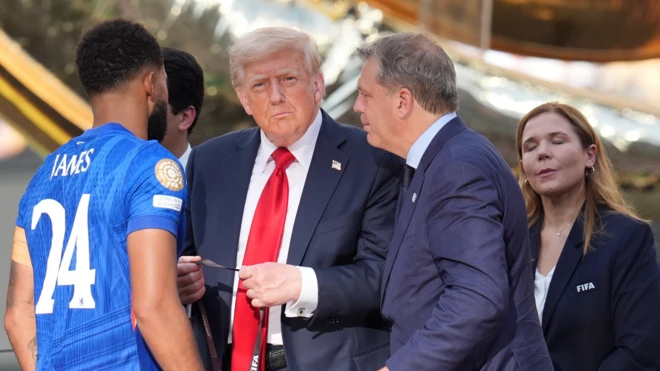 Donald Trump Chelsea'li futbolculara kazandıkları final sonrası madalya takıyor. Yanında yetkililer var.