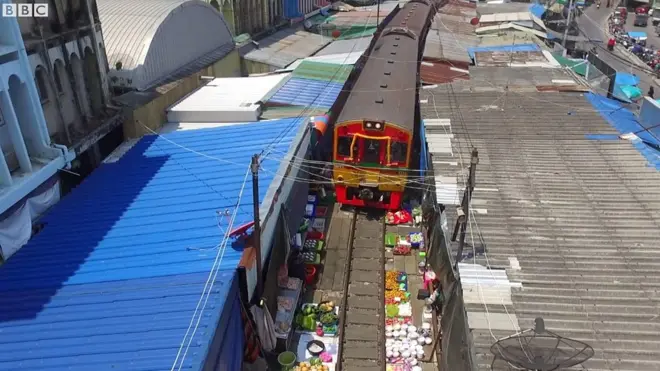 Tàu đi cắt qua chợ Maeklong