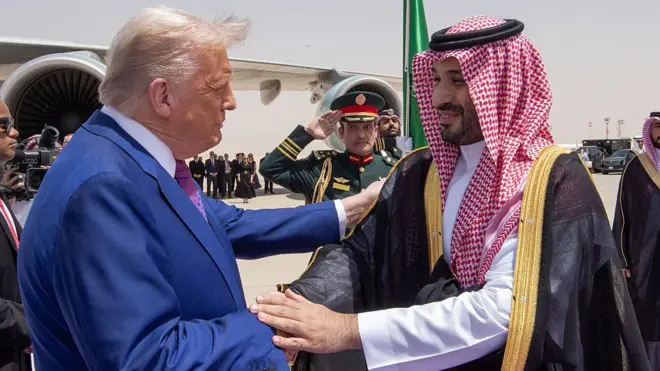 US President Donald Trump (L) shake hand wit Saudi Crown Prince Mohammed bin Salman Al Saud (R) as e arrive Malik Khalid Airport. Trump wear suit while di Prince wear white cloth wit black overall