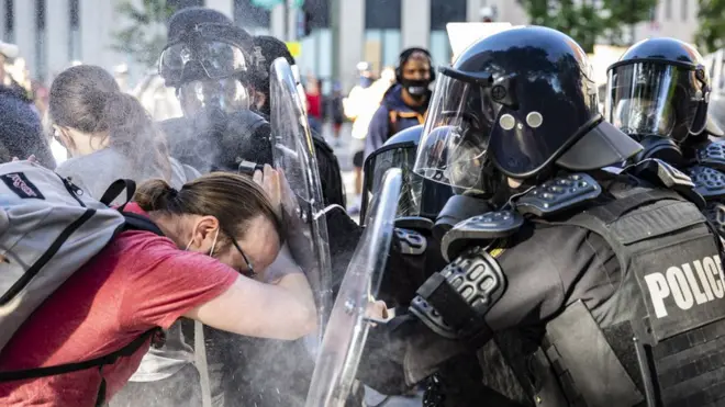 Officers pepper spray a protester while pushing him back during a demonstration over the death of George Floyd, who died in police custody, near the White House in Washington, DC