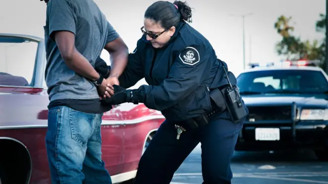 Interpol agent put handcuff for one man hand. 