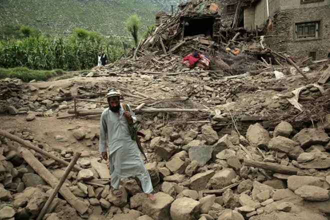 Mandatory Credit: Photo by SAMIULLAH POPAL/EPA/Shutterstock (15466834y) A man walks over rubble next to a damaged house after an earthquake in Kunar, Afghanistan, 01 September 2025. At least 800 people have been killed and some 2,000 injured after a shallow magnitude-6.0 earthquake and several aftershocks shook Nangarhar and Kunar in eastern Afghanistan overnight, officials reported on 01 September 2025. Hundreds killed, thousands injured after earthquake hits Afghanistan, Kunar - 01 Sep 2025