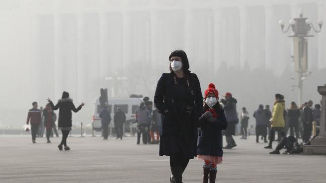 1月4日，兩名頭戴口罩的外國遊客在北京天安門廣場。北京正處於歷史上最長的持續重度污染警報之中。