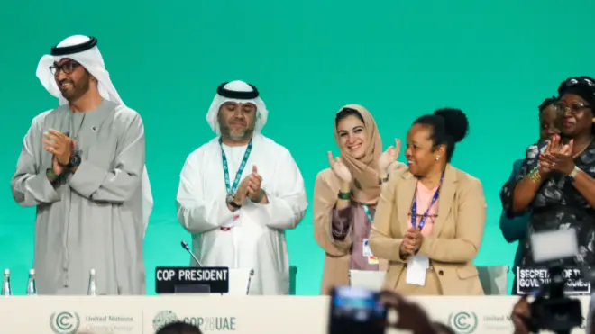 Les délégués applaudissent sur scène après un discours 