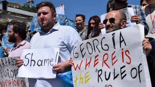 "Позор!", "Грузия, где верховенство закона?" - написано на плакатах участников акции протеста