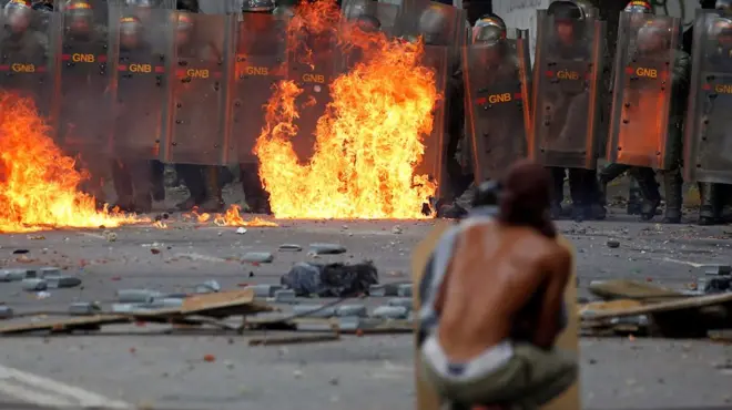 Venezuela'da bir gösterici ve polisler