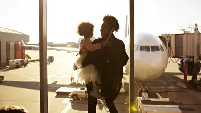 Mother holding daughter at airport