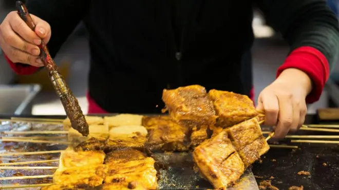 Homem fritando tofu