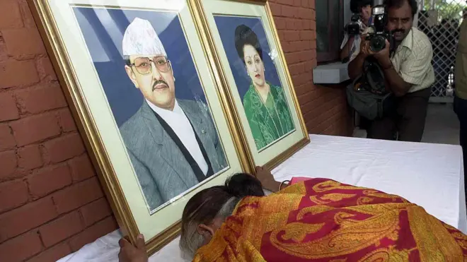 नारायणहिटी राजदरबारको मूलद्वारबाहिर राखिएको राजा वीरेन्द्र र रानी ऐश्वर्यको तस्बिरमा ढोग्दै एक महिला