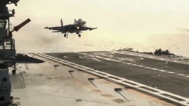 Су-33 садится на палубу авианосца. Хорошо виден посадочный гак и четыре троса, идущих поперек палубы