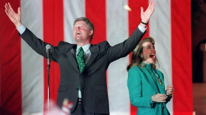 بيل كلينتون عندما كان المرشح الديمقراطي للرئاسة للعام 1993 يلوح للحشود برفقة زوجته هيلاري خلال حفل فوزه في الانتخابات التمهيدية لولاية إلينوي، في 17 مارس/آذار 1992 في شيكاغو. 