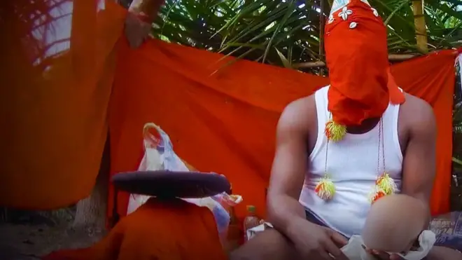 Homem com um capuz vermelho no rosto