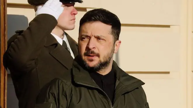 Зеленський в куртці хакі навпроти охоронця загадково дивиться вбік