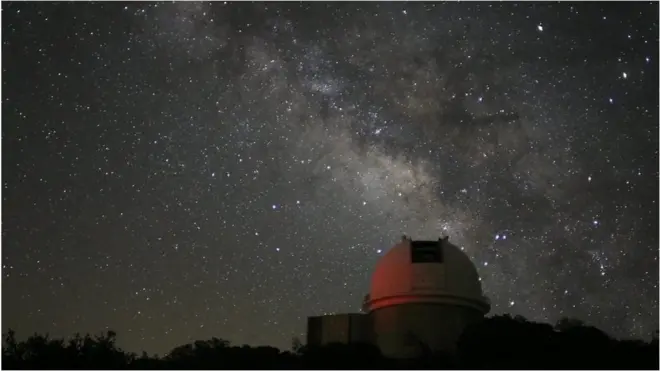 กล้องโทรทรรศน์ ฉากหลังเป็นท้องฟ้าตอนกลางคืน