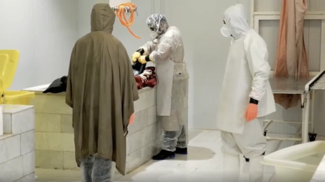 Les gens portent des EPI pour laver les corps des victimes de la corona