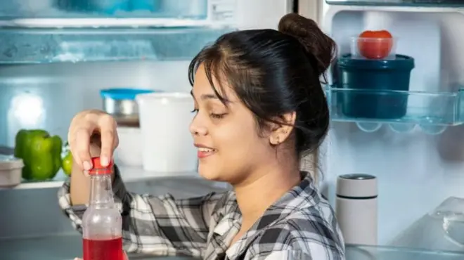 ఫ్రిజ్ నుంచి సీసాను తీసిన మహిళ