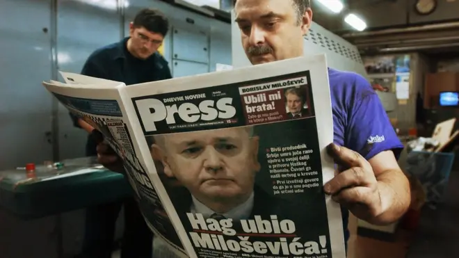 Работник белградской типографии читает номер газеты, сообщающей о смерти Милошевича в тюрьме
