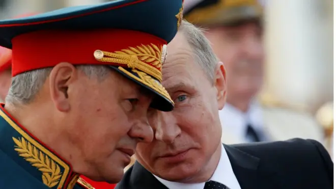 Presiden Rusia, Vladimir Putin, berbicara dengan Menteri Pertahanan, Sergei Shoigu, di St Petersburg, Minggu (30/07).
