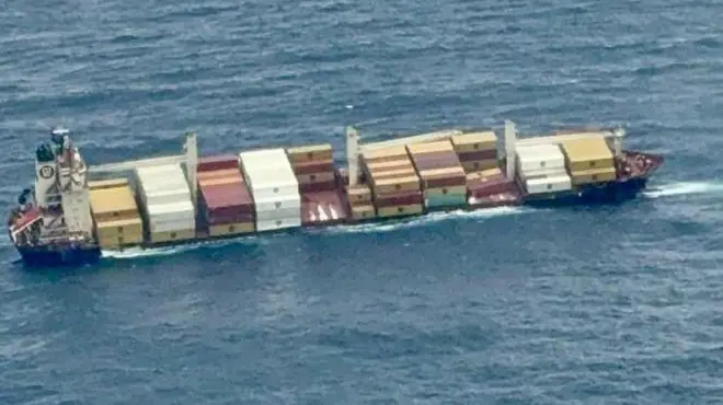 A photo of a ship carrying hundreds of containers tilting dangerously into the Arabian sea on Sunday