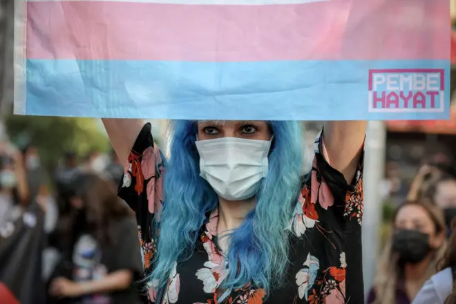 2021'deki Onur Yürüyüşü'nde elinde trans bayrağı tutan birisi
